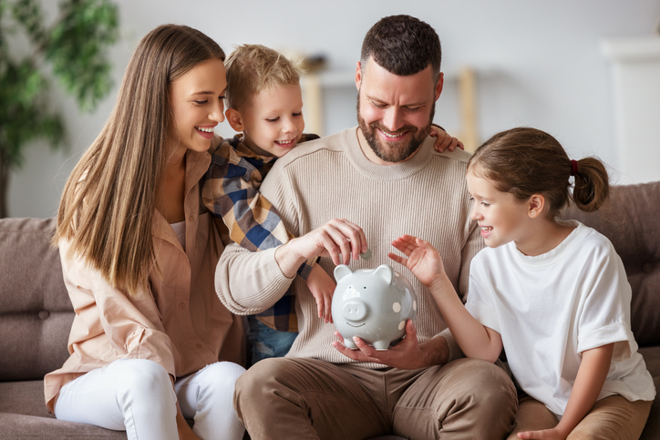 family putting coins in a piggy pank